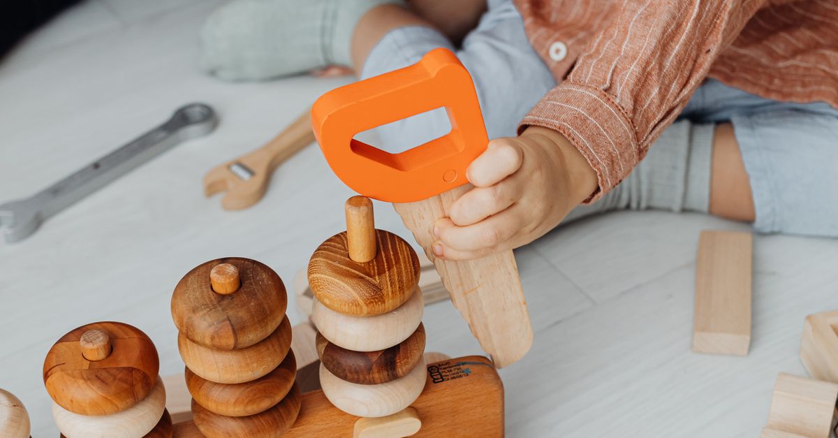 Child holding a colourful wooden educational toy
